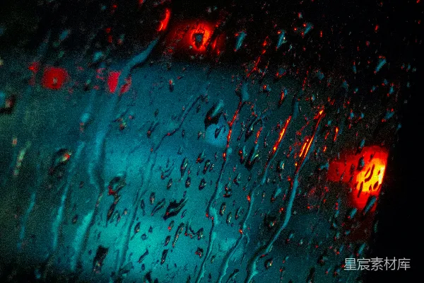 高清摄影 雨滴落在玻璃上，闪烁着红蓝灯光的景象。