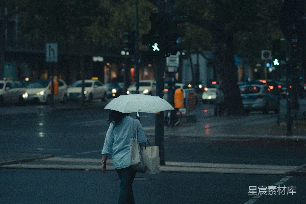 高清摄影 身穿灰色夹克的男人手持雨伞在夜晚街道上行走