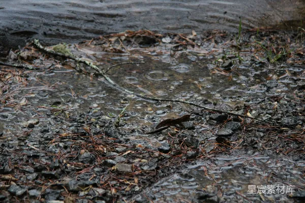 高清摄影 雨滴落在岩石岸边的水里。