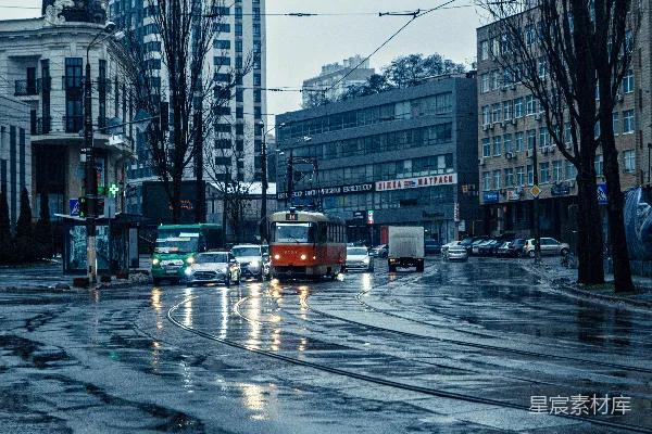 高清摄影 一辆电车和几辆汽车在一条湿漉漉的城市街道上运行。