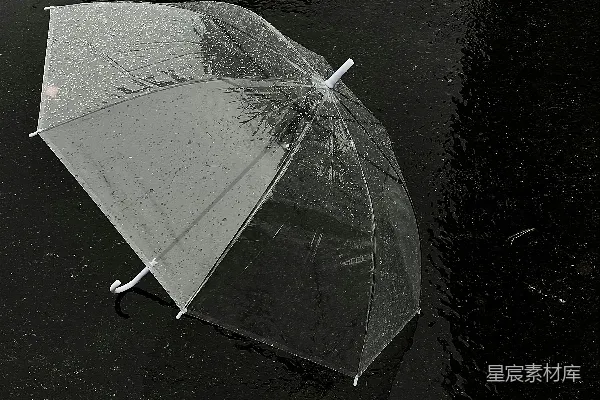 高清摄影 透明伞在湿黑的沥青上覆盖着雨滴。