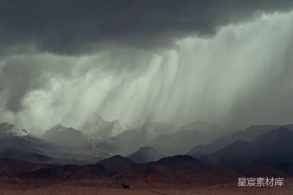 高清摄影 乌云密布，倾盆大雨洒落在崎岖的山峰之上。