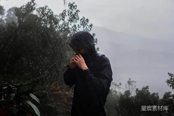 高清摄影 穿着雨衣的人站在雨中