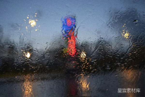 高清摄影 雨夜中城市光线模糊，交通信号灯可见。