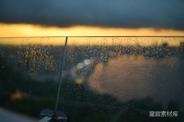 高清摄影 玻璃栏杆上的雨滴与日落背景。