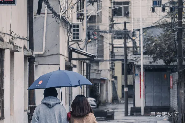 高清摄影 几个拿着伞的人正在街上行走。