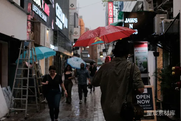 高清摄影 一个女人走在街上拿着雨伞
