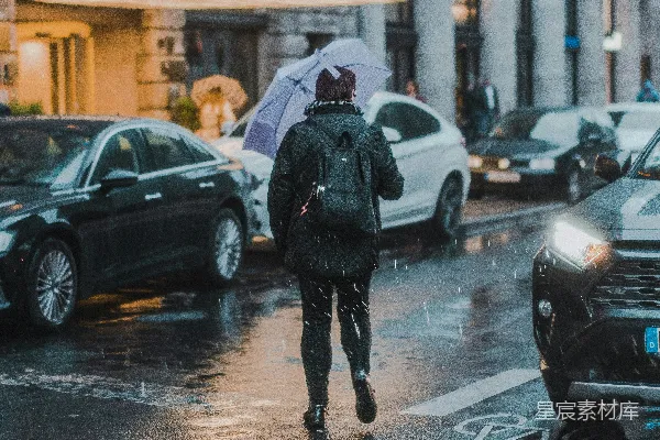 高清摄影 一个男人在雨中打着伞行走。