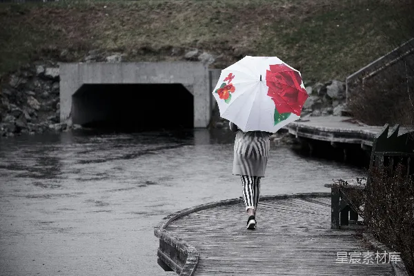 高清摄影 女人在水边行走时拿着雨伞