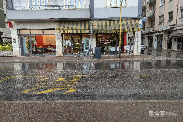 高清摄影 前面一栋建筑前有一条湿漉漉的街道，一辆自行车停在那前方。