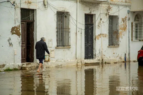 高清摄影 行人走在前面有旧建筑的 flooded 街道上