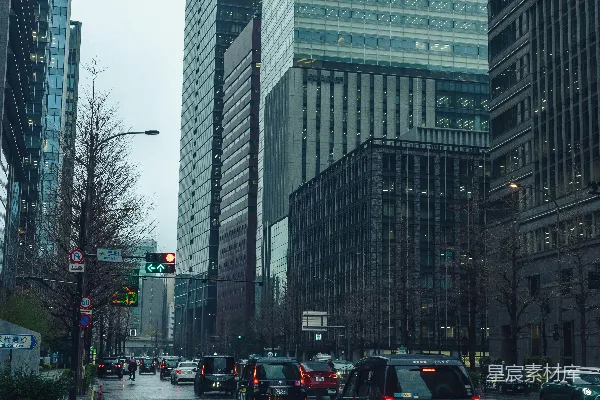 高清摄影 汽车行驶在湿滑的城市街道上，高楼林立。