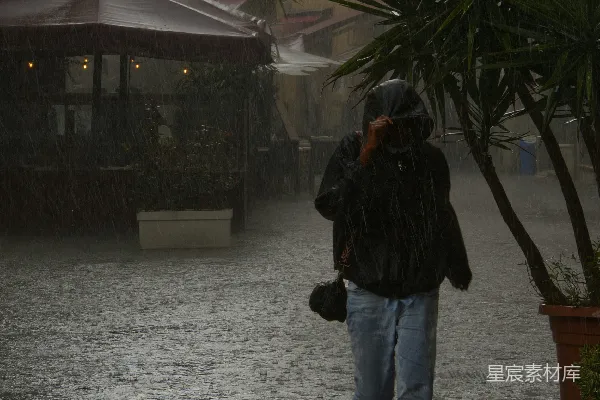 高清摄影 行人穿过一个雨中的欧洲街道。