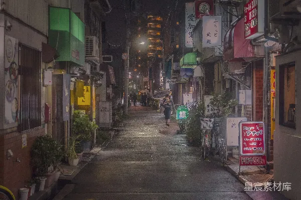 高清摄影 夜晚一条狭窄的城市街道上有人在行走。