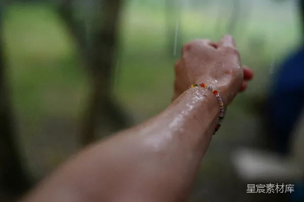 高清摄影 湿漉漉的手臂和握紧的拳头上戴着手链。