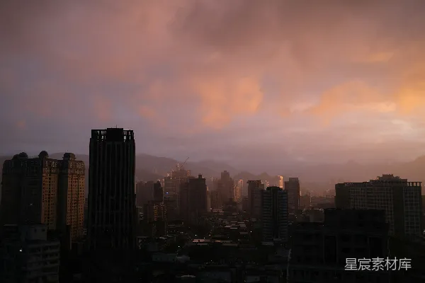 高清摄影 夕阳下的城市景色，天空中有云朵。
