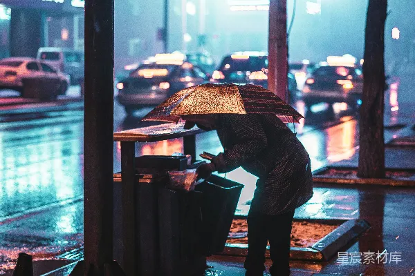 高清摄影 身穿粉红色衬衫和黑色长裤的男人在夜间的步行街上拿着雨伞走路