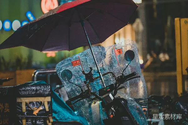 高清摄影 一辆带伞的滑板车停在雨中