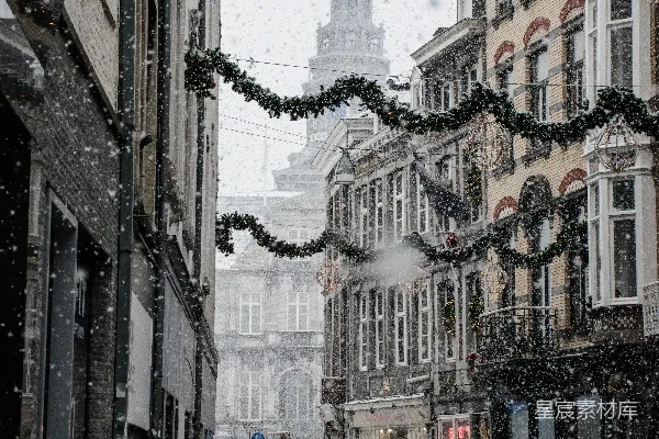 高清摄影 行人走在棕色建筑附近街道上，正值雪季。