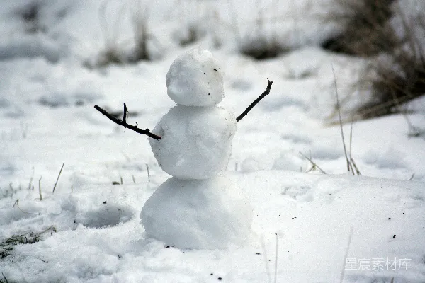 高清摄影 雪地里一张拿着树枝的手的雪人照片