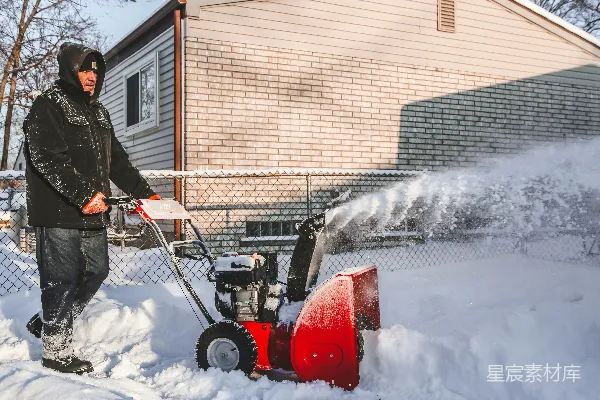 高清摄影 红白相间的雪地车在覆盖着白雪的地面上行驶。