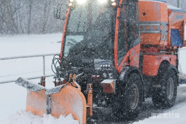 高清摄影 一辆雪犁在覆盖着积雪的道路上行驶。
