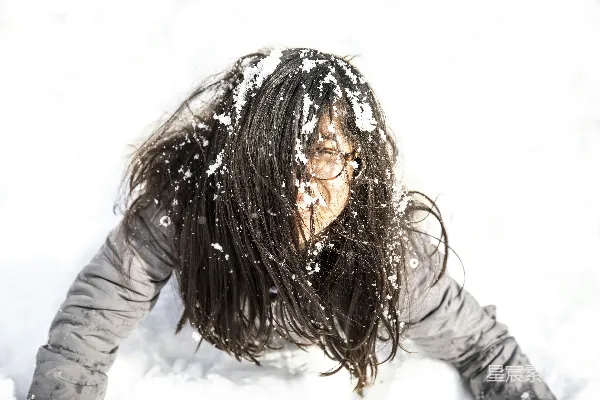 高清摄影 灰衣女子躺在覆盖着积雪的地面上