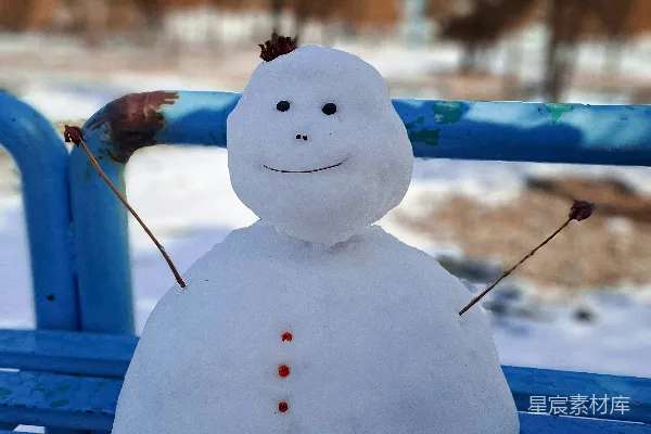 高清摄影 雪人坐在蓝色长凳上，背景是雪地。