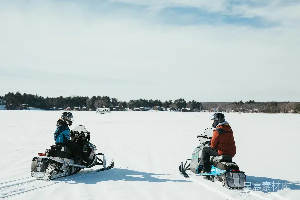 高清摄影 两人在雪地里骑雪地摩托