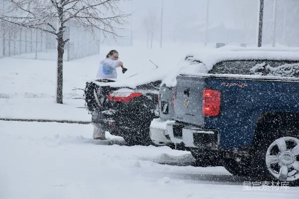高清摄影 一个女人站在一辆卡车顶上，雪地中。