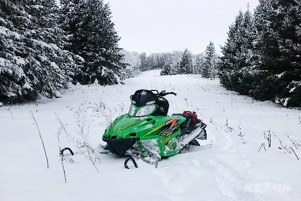 高清摄影 雪地摩托在树丛间的雪场中行驶