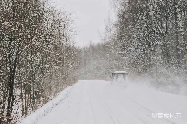 高清摄影 一辆卡车在覆有白雪的道路旁行驶。