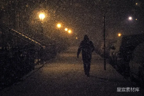 高清摄影 夜晚行人戴着帽子在雪中行走
