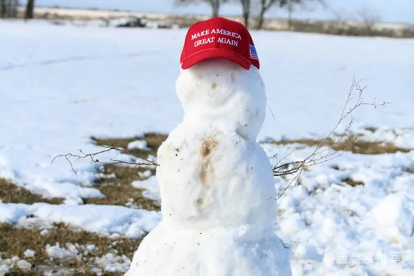 高清摄影 雪地上的戴着红针织帽的雪人，在白天的地面上