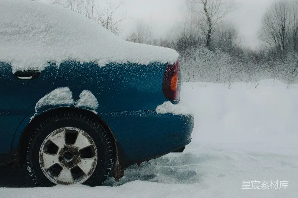 高清摄影 一辆覆盖着积雪的蓝车在下雪的日子里。