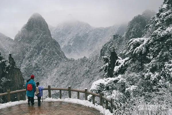 高清摄影 几个人在山顶上站着，山顶被雪覆盖着。