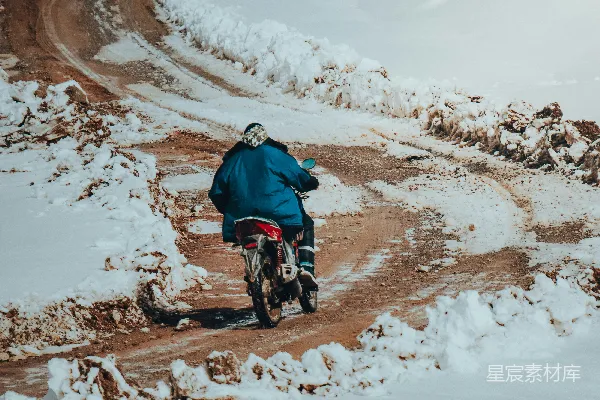 高清摄影 一个男人骑着摩托车在一条被白雪覆盖的道路上行驶