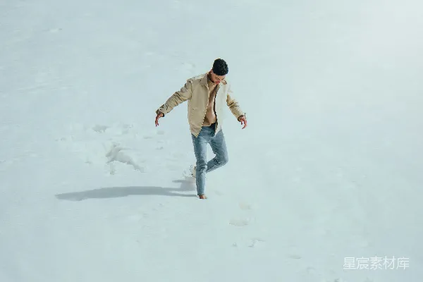 高清摄影 一个男子骑着单板从覆雪的斜坡下滑。