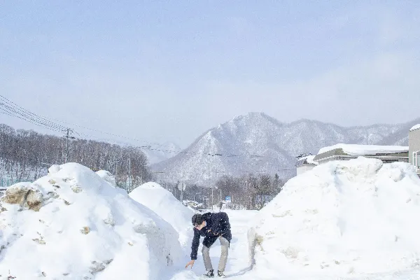 高清摄影 跪在雪地里旁边的一个雪堆上的男人
