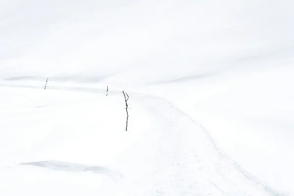 高清摄影 一个男子在覆盖着白雪的山坡上滑翔而下