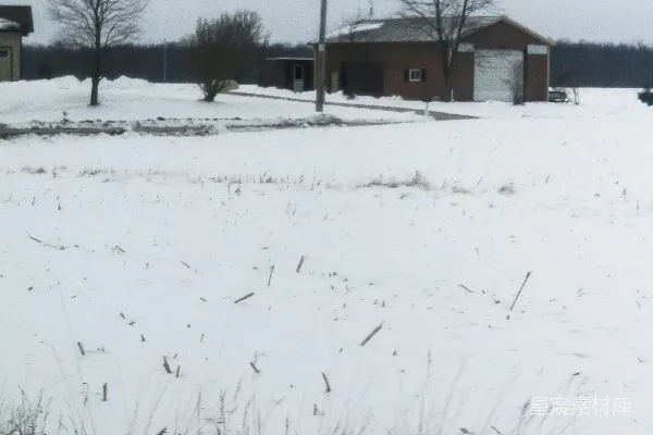 高清摄影 背景中有房屋的雪覆盖田野