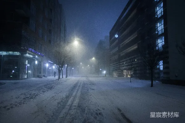 高清摄影 夜晚建筑物之间覆盖着白雪的道路