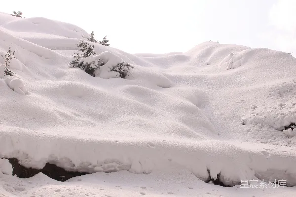高清摄影 一个男子在覆盖着积雪的山坡上滑雪板
