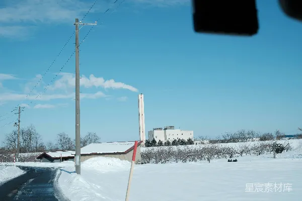 高清摄影 背景中有座建筑的雪地小路