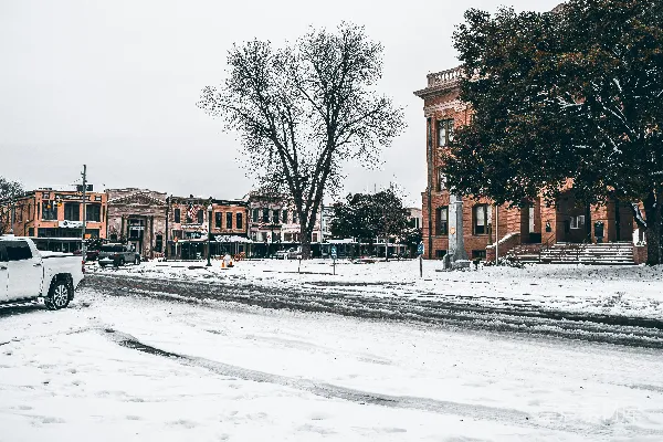高清摄影 一辆白色卡车在覆有白雪的街道上行驶。