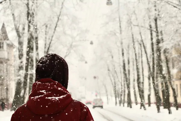 高清摄影 一个穿红色夹克的女人走在覆有白雪的小街上