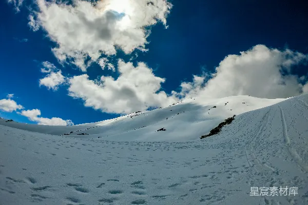 高清摄影 白天的蓝天白云下，皑皑白雪覆盖着山峰。