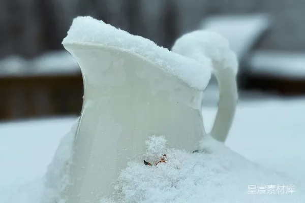 高清摄影 覆盖着积雪的水壶放在一堆积雪之上