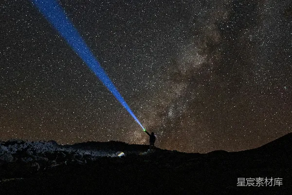 高清摄影 山顶上站着一个人，天空中繁星点点。