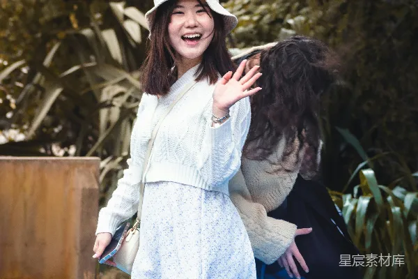高清摄影 一个穿着白色连衣裙和帽子的女人站在蓝色的泳池中。